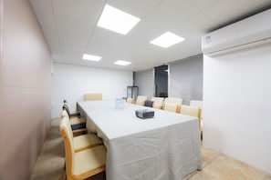 A conference room with a long table, chairs, and a white tablecloth. - Yuelin Hotel (Fuzhou)