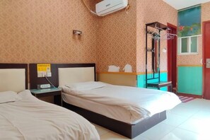Une chambre d’hôtel avec deux lits, une table de chevet, un climatiseur, un radiateur mural et une fenêtre donnant sur un beau paysage.
