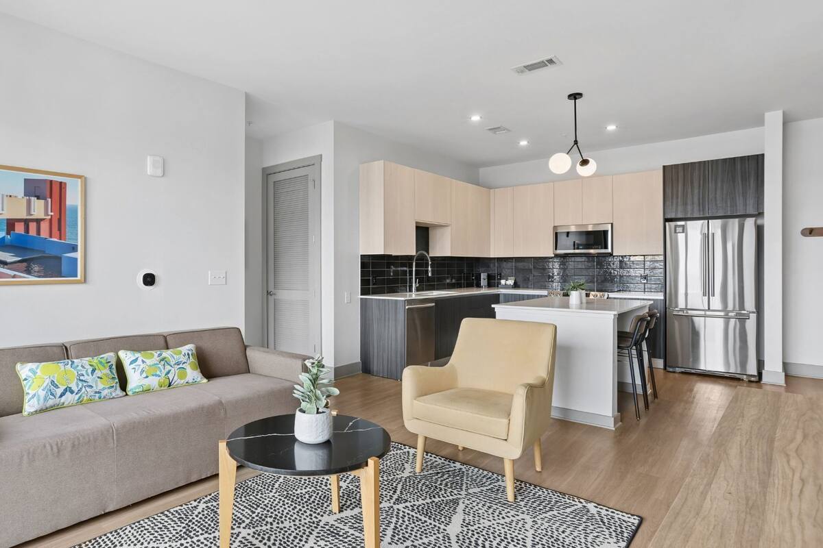 A modern apartment with a living room, kitchenette, and a dining area.
