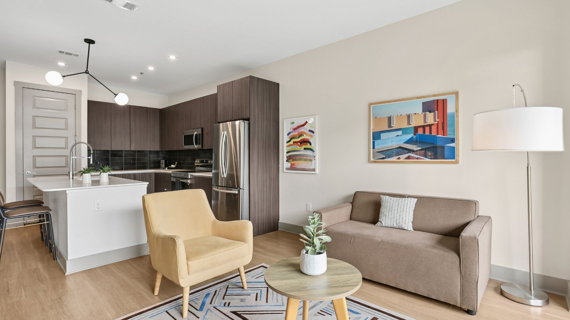 A modern apartment with a kitchen, a dining area, a sofa, and a coffee table.
