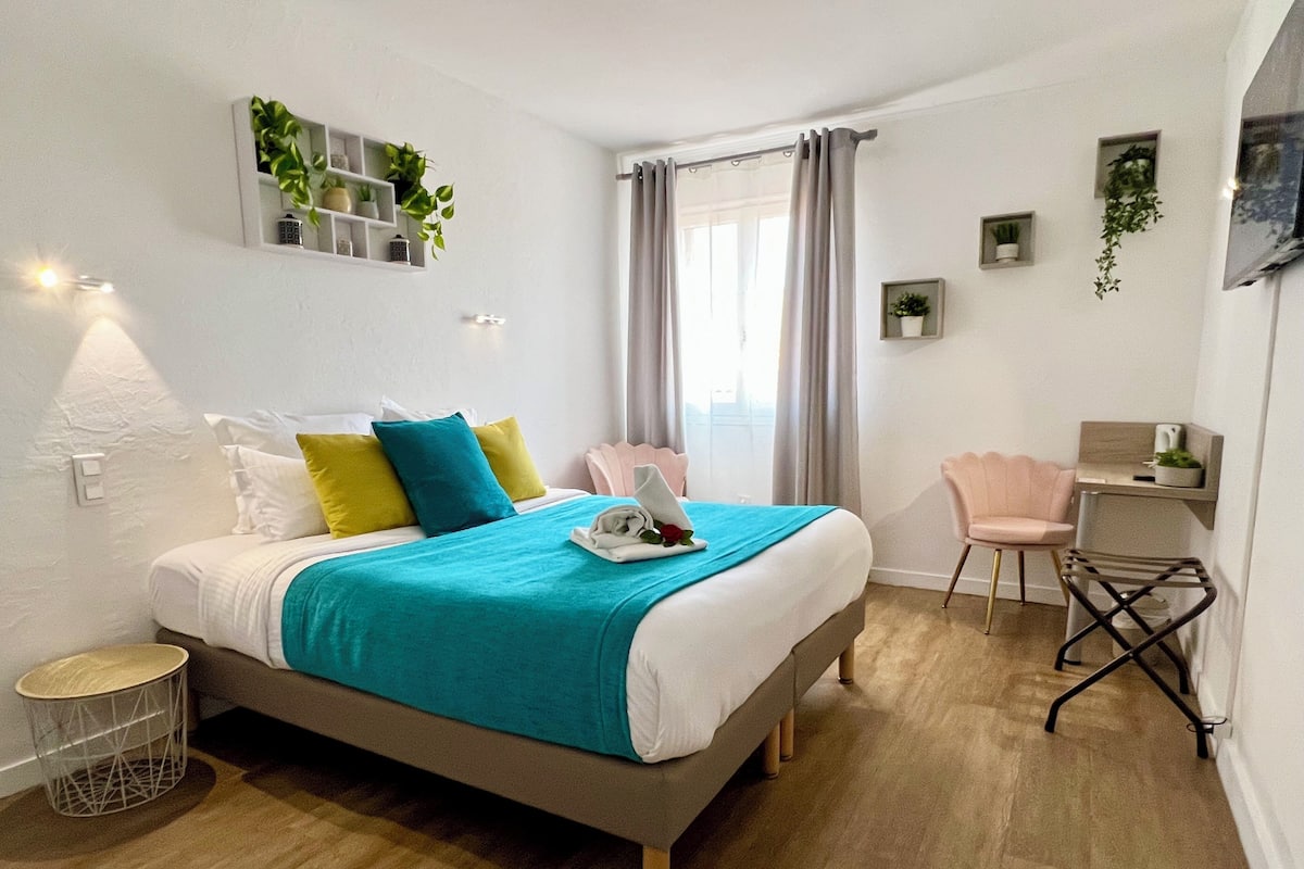 A modern bedroom with a bed, bedside table, and a desk area.