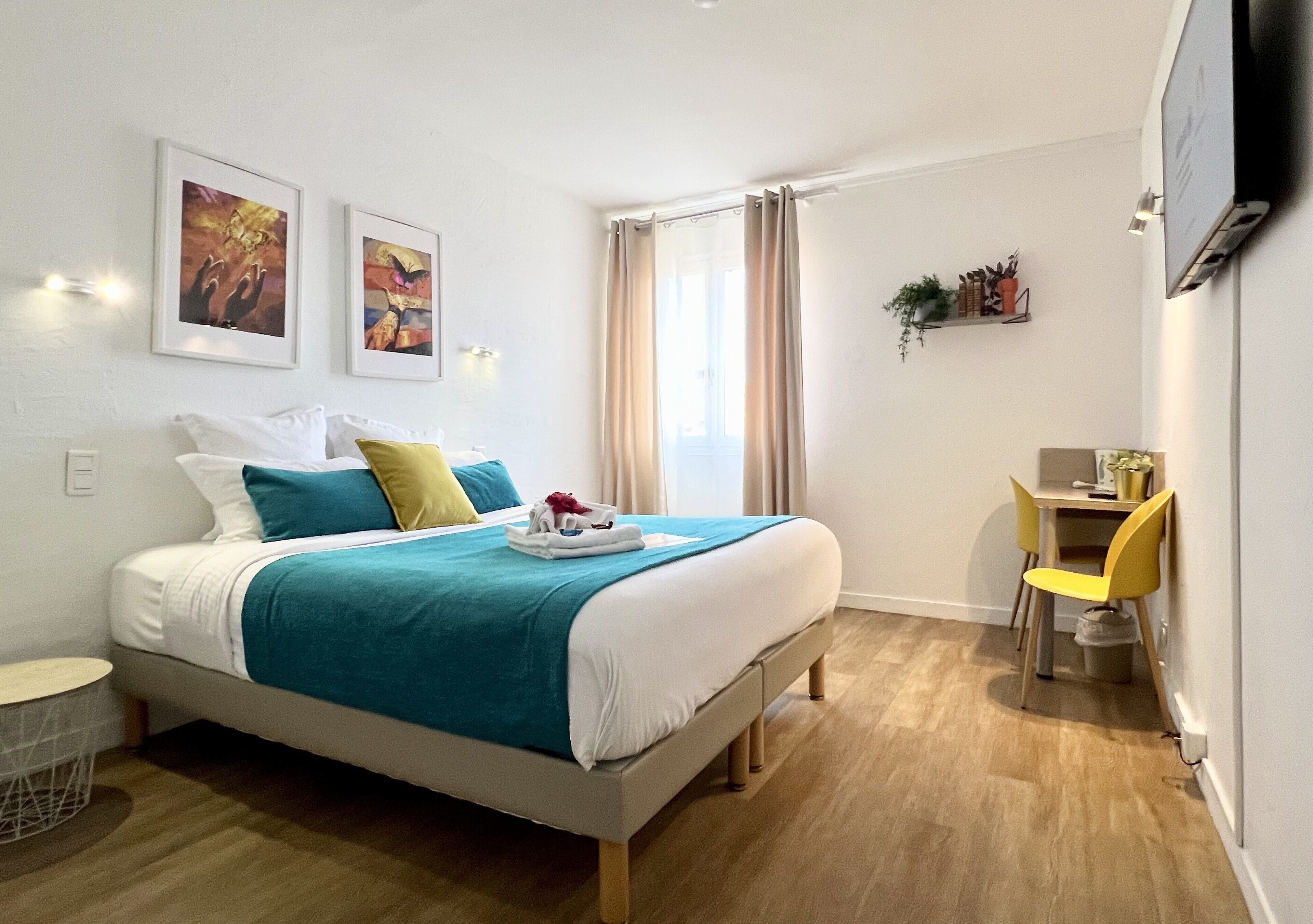 Een hotelkamer met een bed, een bureau, een stoel en een televisie.