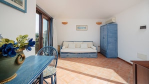 Una habitación con una mesa de comedor, sillas, un sofá y un armario.