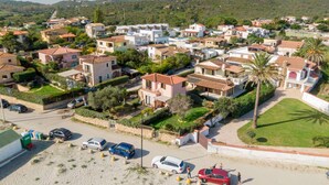 Zona residencial con casas, coches y una palmera.