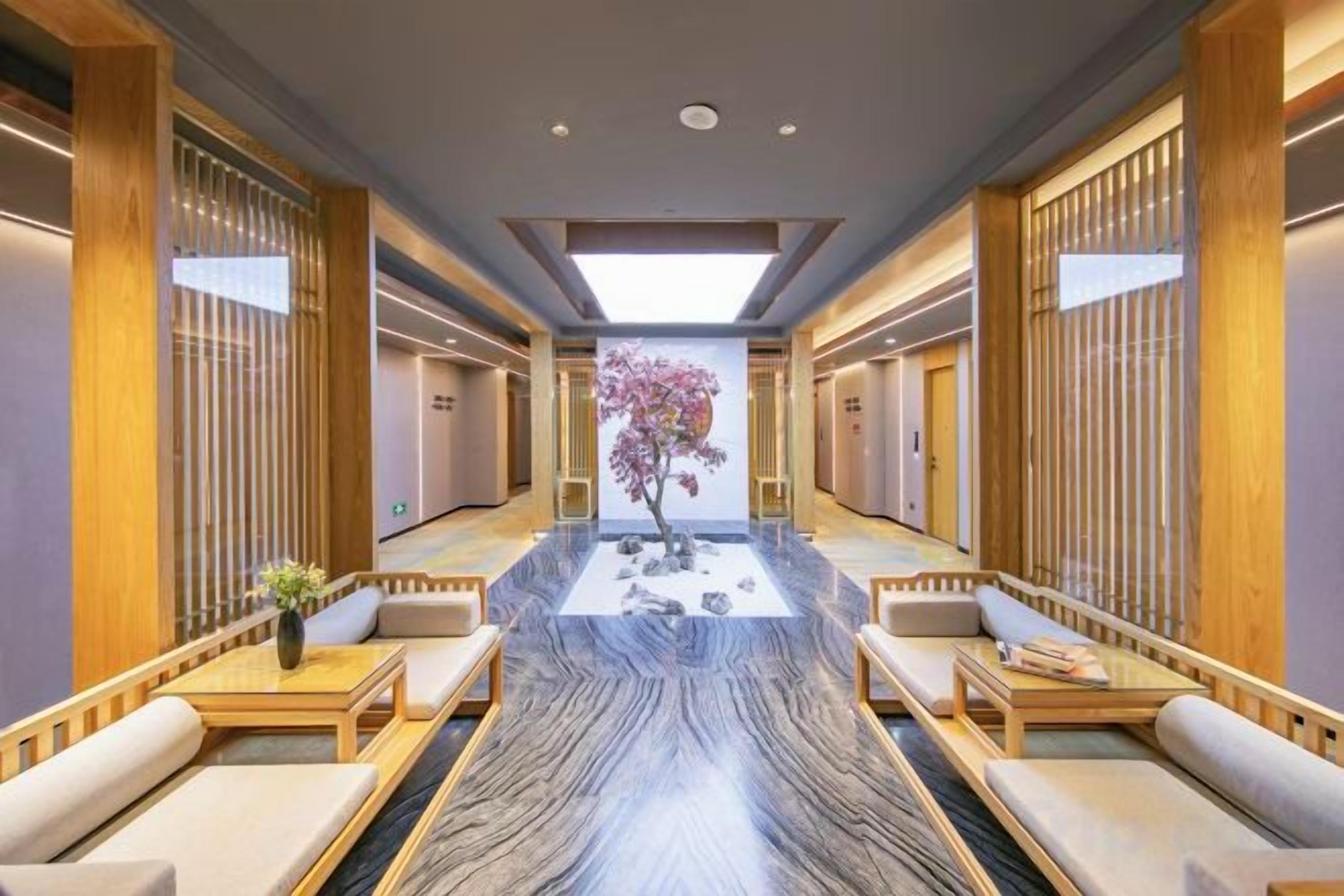 A hotel lobby with a central seating area, wooden partitions, and a large window.