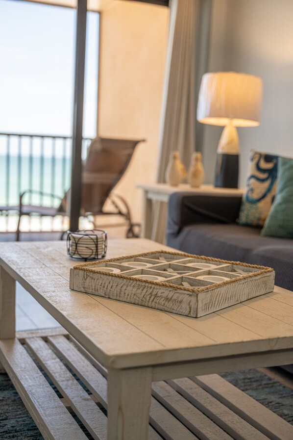 A wooden coffee table with a woven tray, a lamp, and a sofa with a cushion in a living room.