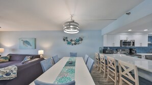 A modern kitchen with white cabinets, a microwave, and a coffee maker.