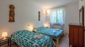 A room with two beds, a wooden cabinet, and a window with sheer curtains. - VILLA WITH POOL FOR 14 PEOPLE COMPLETELY FENCED IDEAL FOR VISITING (Marche)