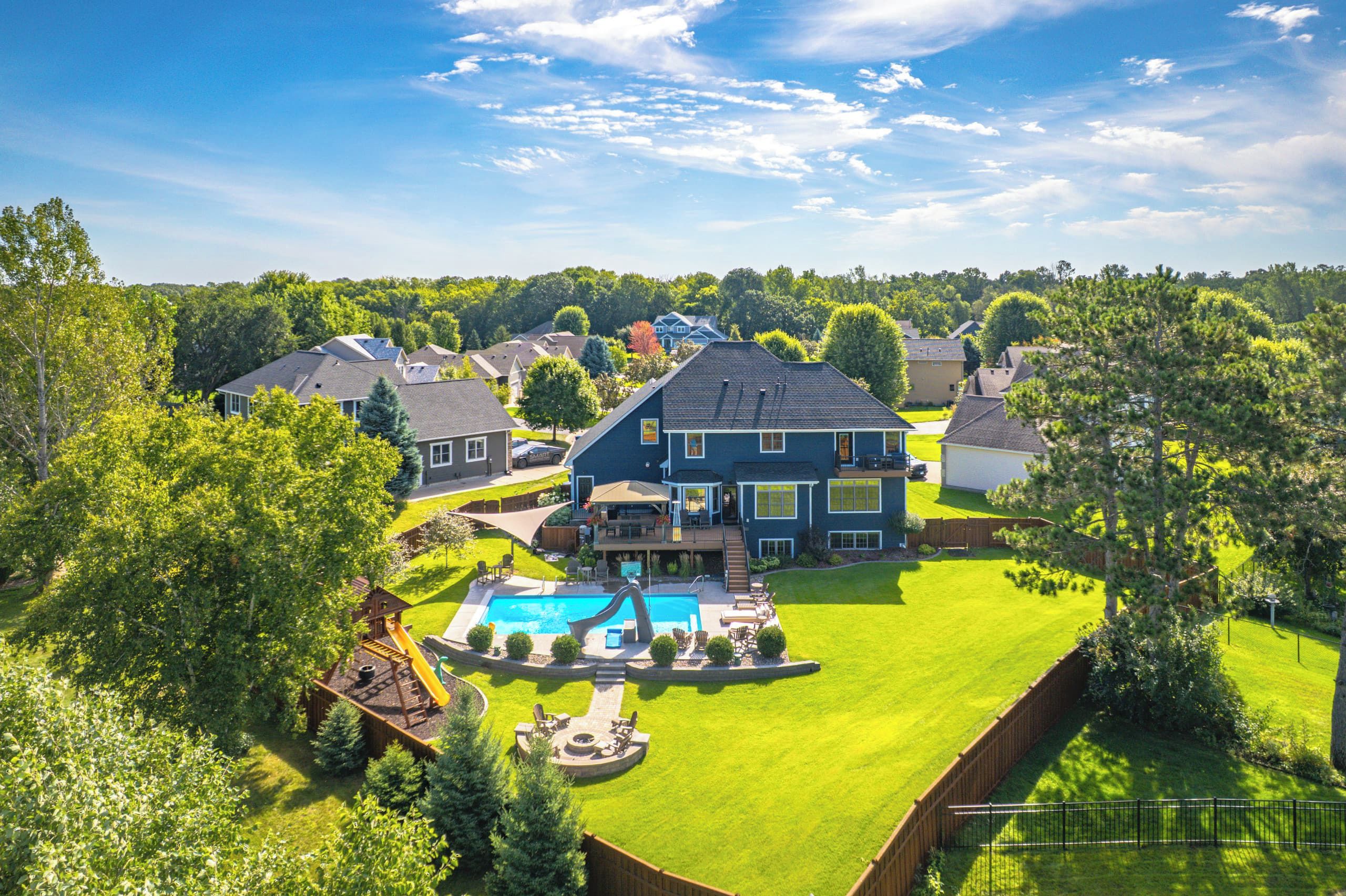 Aerial view of the home, pool and big green yard in an Elk River neighborhood.