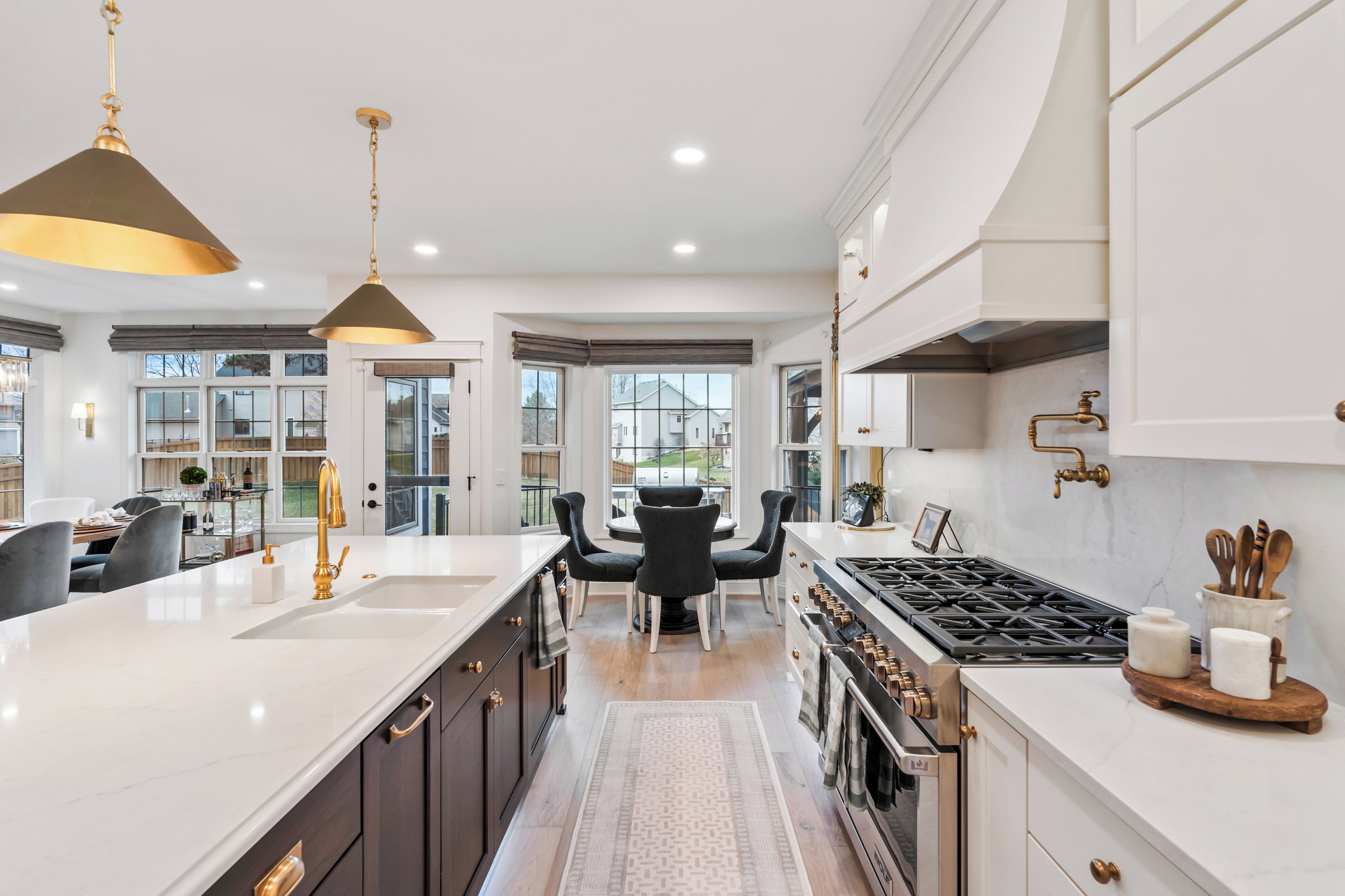 A modern kitchen with a central island, dark cabinetry, and stainless steel appliances.