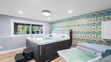 A bathroom with a hot tub, a shower, and a window with a view of the outdoors.