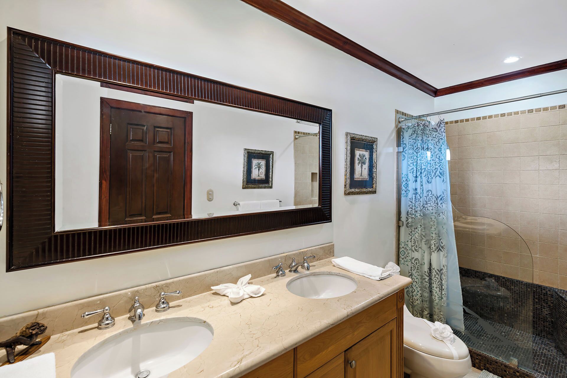 A bathroom with two sinks, a large mirror, and a shower with a glass door.