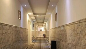 A long, narrow hallway with marble walls and a wooden floor, leading to a reception area at the end. - Homeinn Pebble Hotel (Zhengding Airport) (Zhengding)