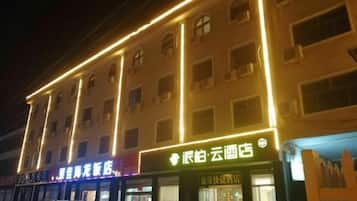 A multi-story building with illuminated signage, including a restaurant and a store.