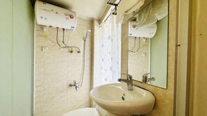 Un baño con inodoro, lavabo y ducha.