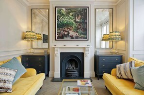 A living room with a fireplace, two sofas, and two lamps. - Elegant 4 Bedroom House - Clapham (London)