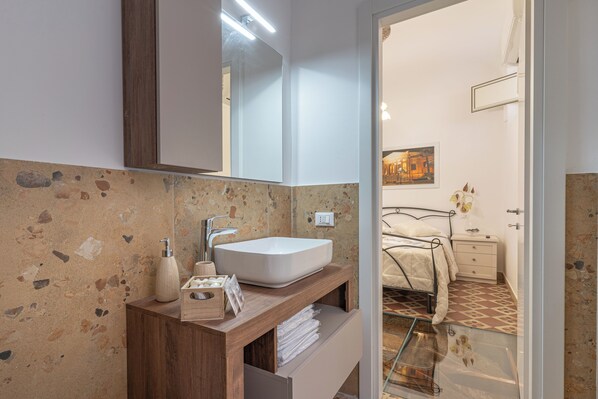Une salle de bain avec un meuble-lavabo en bois, un lavabo blanc et un grand miroir.