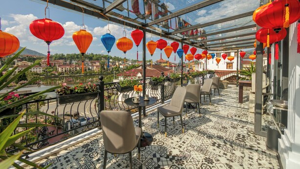 Terraza en la azotea con techo de vidrio, mobiliario exterior y vistas a la ciudad.