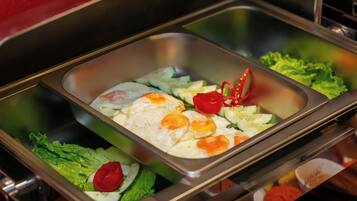 A buffet with various food items including eggs, lettuce, and tomatoes.