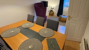 A dining area with a table, chairs, and a purple accent chair. - 2 Bed-sleeps 3-parking-town Centre (Northallerton)