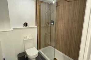 Bañera con ducha, bañera profunda, secador de pelo, toallas