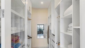 A narrow hallway with white storage units on either side, leading to a door at the end. - Stylish Villa with Brand-New Furniture, Panoramic Ocean Views, and Infinity Swimming Pool & Hot Tub (Potrero)