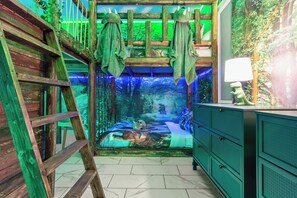 A room with a bed featuring a forest-themed bedspread, a ladder, a dresser, and a wall with a forest mural. - Disney Area Home, Pvt Pool, Hot Tub, PS5 & Fun Themed Rooms (Kissimmee)