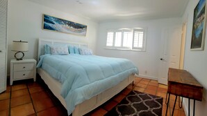 A bedroom with a bed, nightstand, lamp, window, and door. - Charming waterfront house with 3-bedrooms, 3-full bathrooms and pool (Pompano Beach)