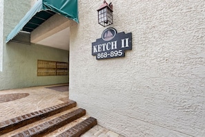 A building entrance with a sign reading "KETCH II 868-895" and a lantern above it.