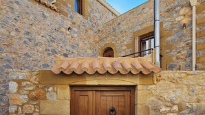A stone building with a wooden door and a small window.