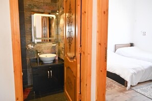 A bathroom with a sink, mirror, and wooden door. - Twilight Palace (Luxor)