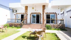 A white building with a covered patio, stone columns, and a staircase leading to the entrance. - Twilight Palace (Luxor)