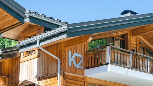 A multi-story wooden building with balconies and large windows, likely a hotel or lodge. - Wifi, 150m from ski slopes, 1st floor, balcony, parking, tv, 67m², Les Gets (Les Gets)