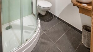 A modern bathroom with a glass-enclosed shower, a white toilet, and a wooden vanity with a sink. - Wifi, 150m from ski slopes, 1st floor, balcony, parking, tv, 67m², Les Gets (Les Gets)