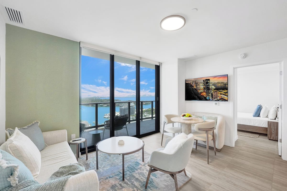 Ein modernes Wohnzimmer mit Balkon, Essbereich und Schlafzimmer.