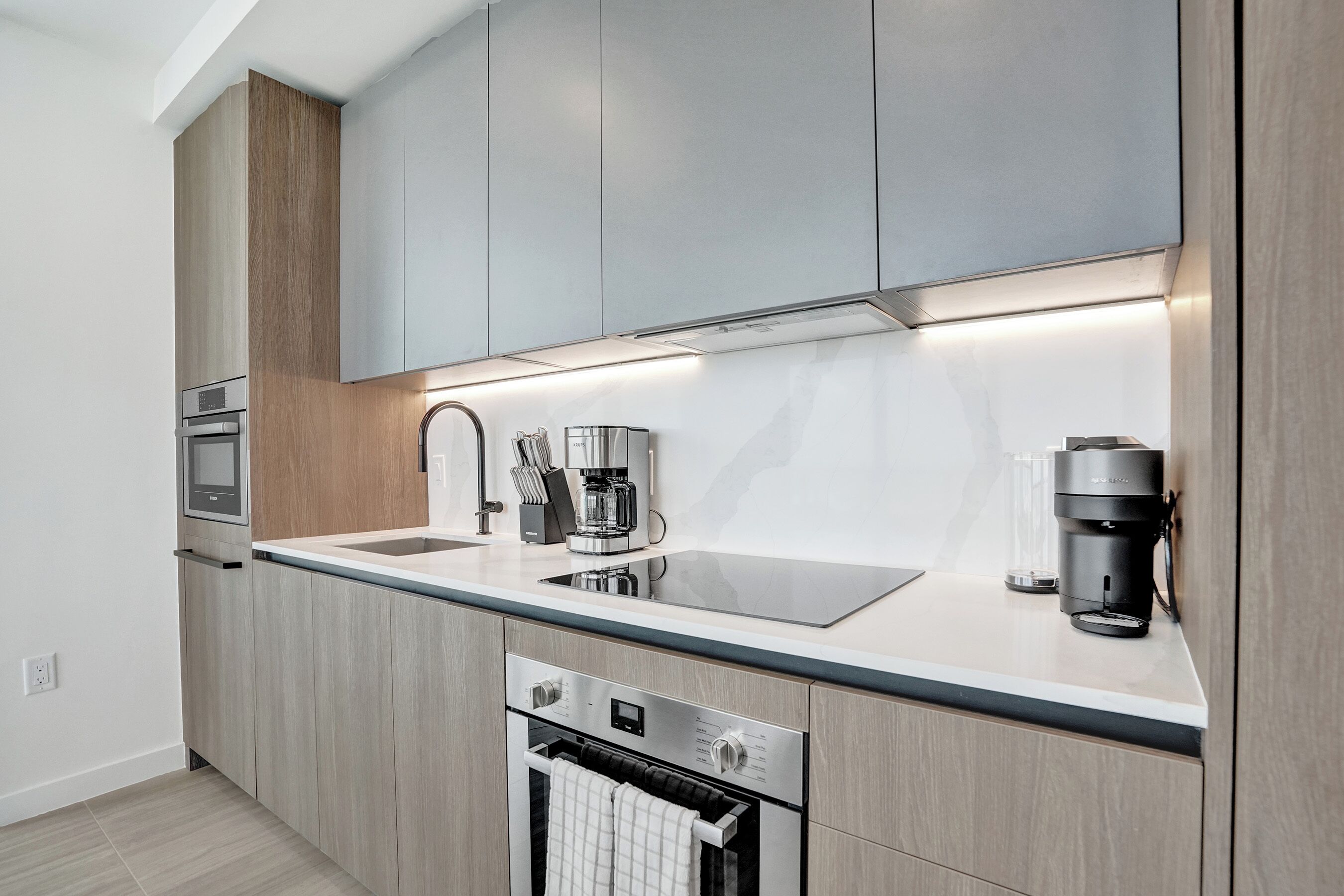 A modern kitchen with built-in appliances, a large countertop, and a sleek design.
