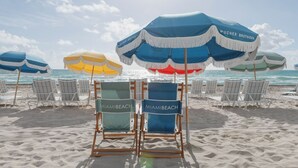Beach chairs with towels, a blue umbrella, and a beach view. - 72 Park - Miami Beach by Nomada (Miami Beach)