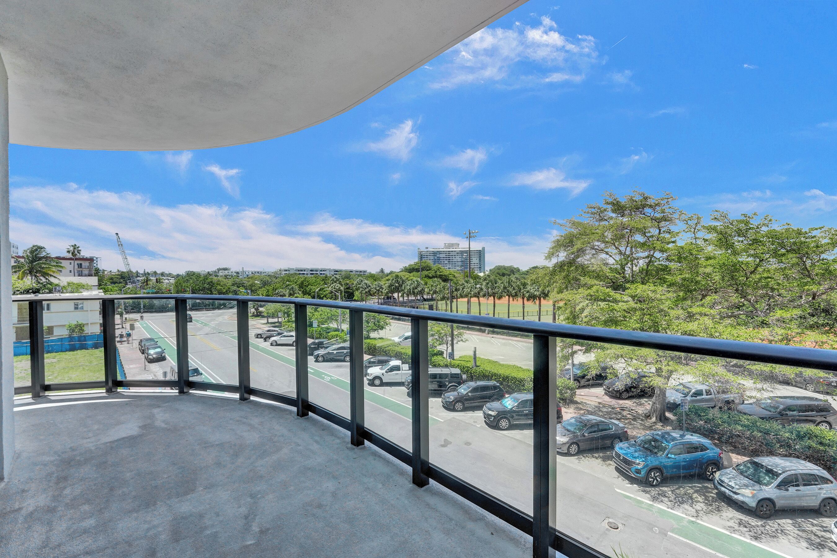 A balcony with a view of a parking lot and a road.