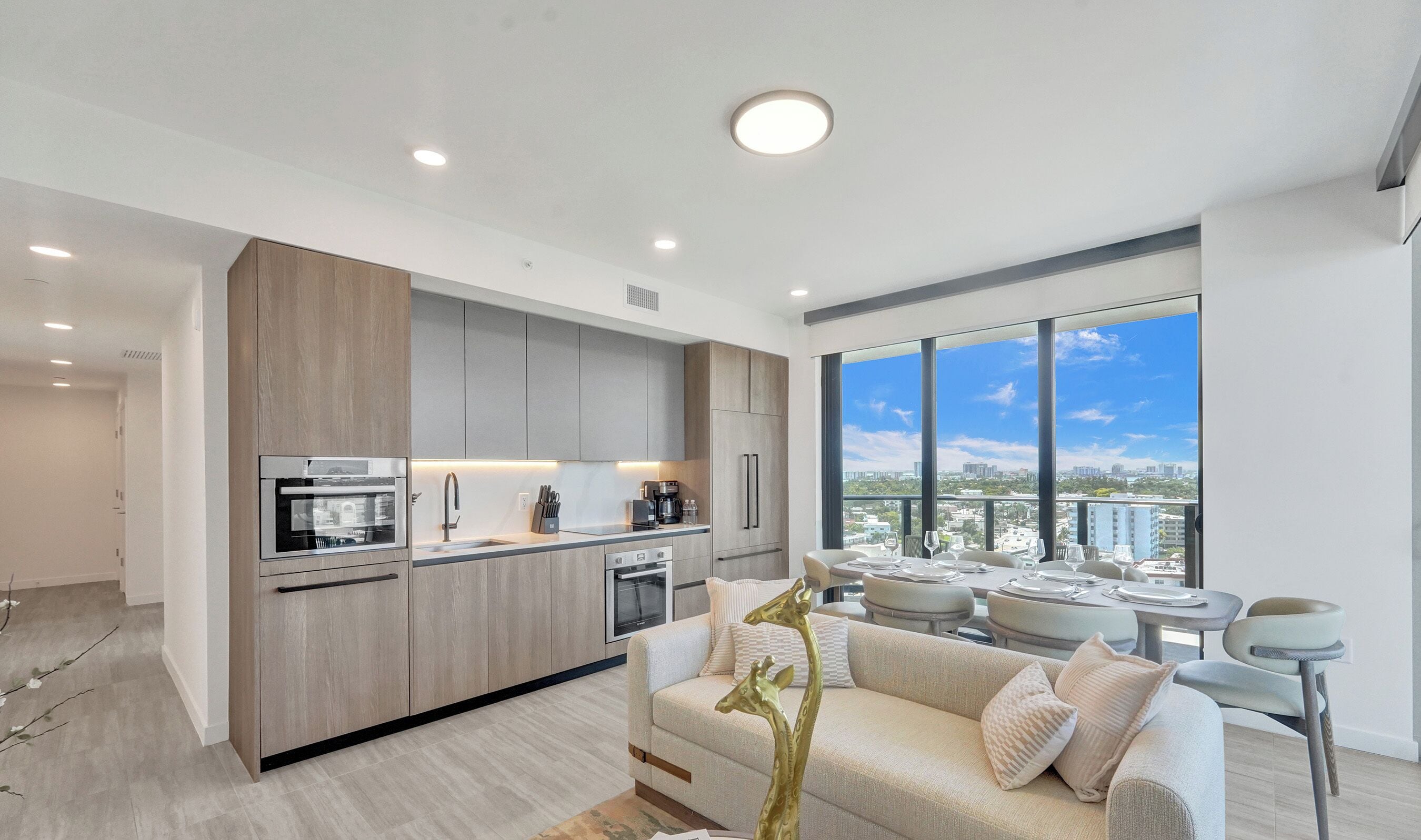 Una cocina moderna con electrodomésticos integrados y un comedor con vistas a la ciudad.