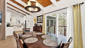 Un comedor con una mesa de madera, cuatro sillas y individuales tejidos.