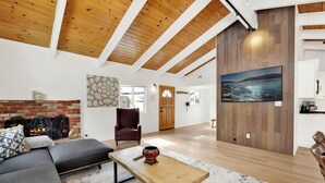Una sala moderna con chimenea, un cuadro grande y un rincón de estar acogedor.