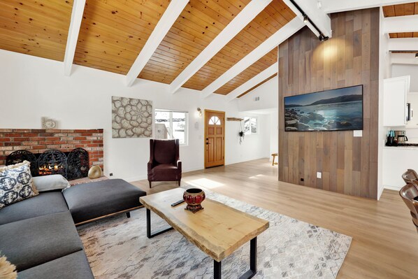 Un salon moderne avec une cheminée, un grand tableau et un coin salon confortable.