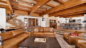 A spacious living area with leather sofas, a dark coffee table, and a wooden ceiling. - Bear Lake Lodge #2547 (Big Bear Lake)