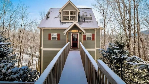 Une maison à deux étages avec une allée couverte menant à la porte d’entrée.