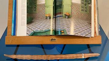 Ein offenes Magazin auf einem hölzernen Ständer, darunter ein blauer Tisch.