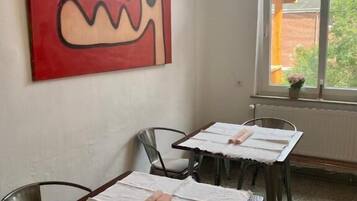 Een koelkast met diepvriezer, een kookplaat, kookgerei, borden en bestek