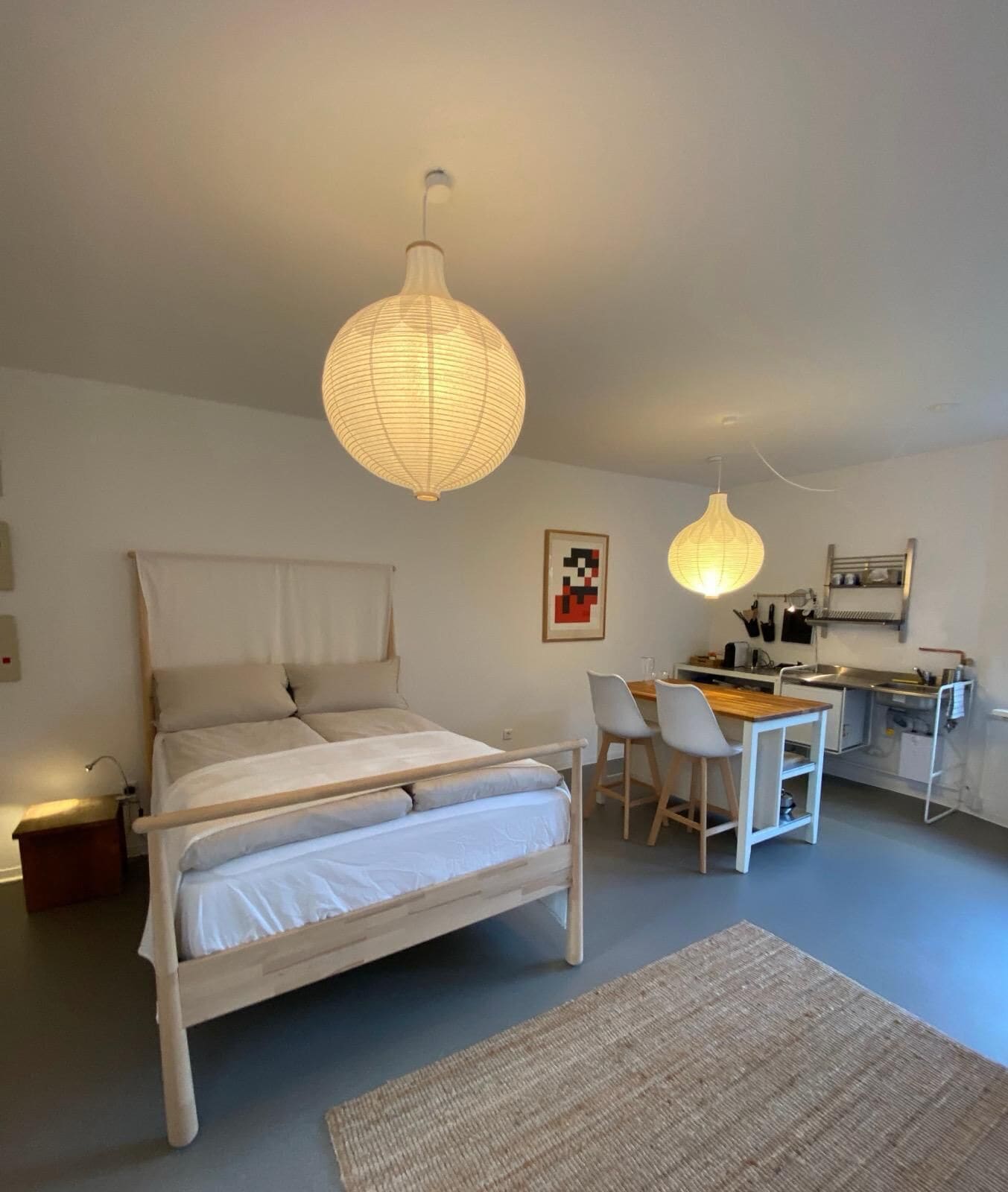 Ein Schlafzimmer mit Bett, Nachttisch und kleinem Schreibtisch mit Stühlen.