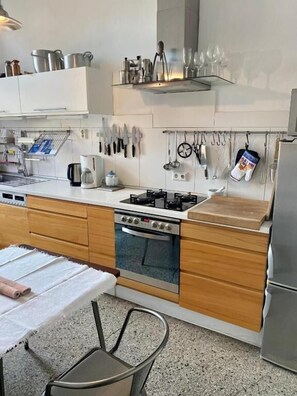 Full-sized fridge, stovetop, cookware/dishes/utensils