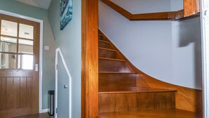 A wooden staircase with a handrail leading to a landing. - 1 Rumsby Cottages (Lowestoft)
