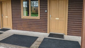 A wooden cabin with two doors labeled "Cherry" and "Chestnut," each with a small window and a keypad lock. - Chestnut (Cowbridge)